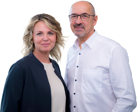 Portrait von Patricia vom Schemm (links), Inhaberin in einer dunklen Jacke über einem hellen Oberteil, und Friedo vom Schemm (rechts), Inhaber mit Brille und weißem Hemd.